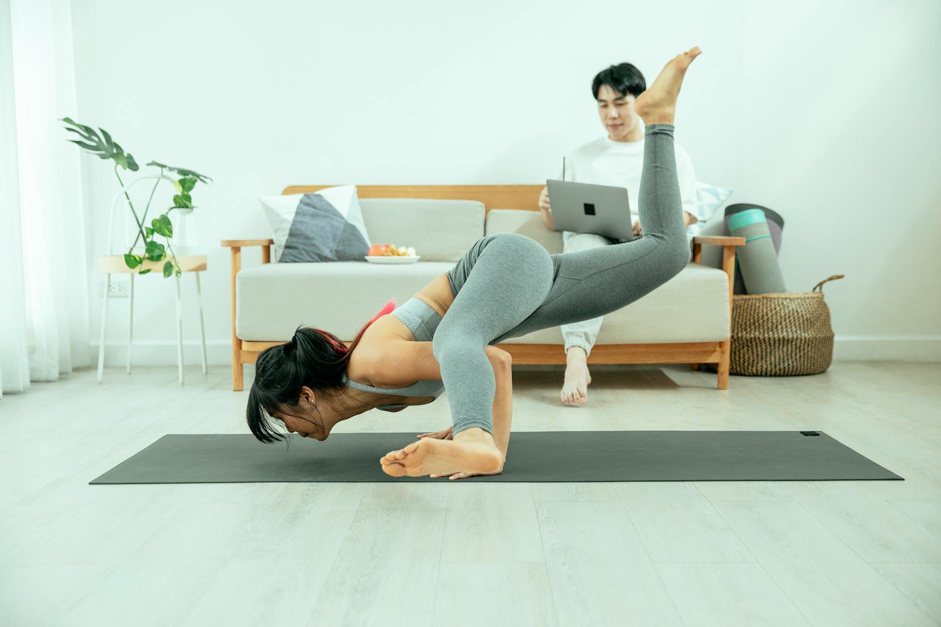 Woman in a calm yoga pose on a mat in a bright, modern room